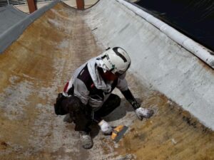 体育館屋根 防水工事 下地ケレンと清掃作業の様子